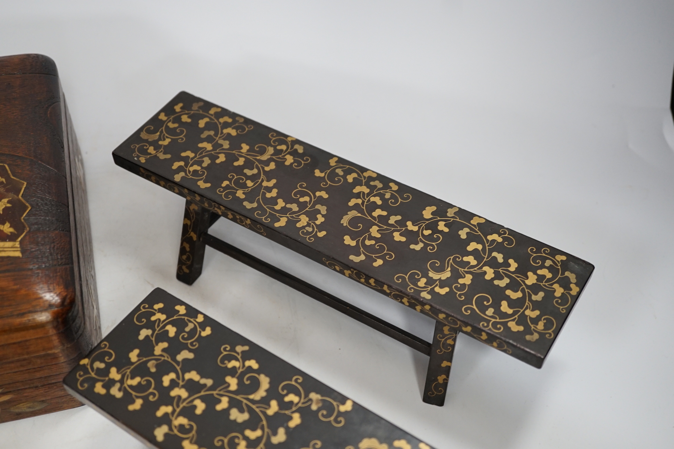 A group of Japanese lacquer wares, comprising pair of miniature benches and two boxes, Meiji period and later, largest 25cm wide